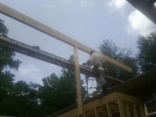 Carpenter setting a ridge beam over a new addition frame — Ice Dam Removal by Roofing Brothers in Mooresburg