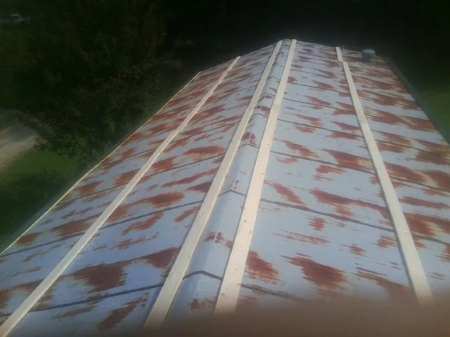 Rusted metal roof panels with new wood purlins before replacement — Storm Damage Roof Repair in Mooresburg by Roofing Brothers