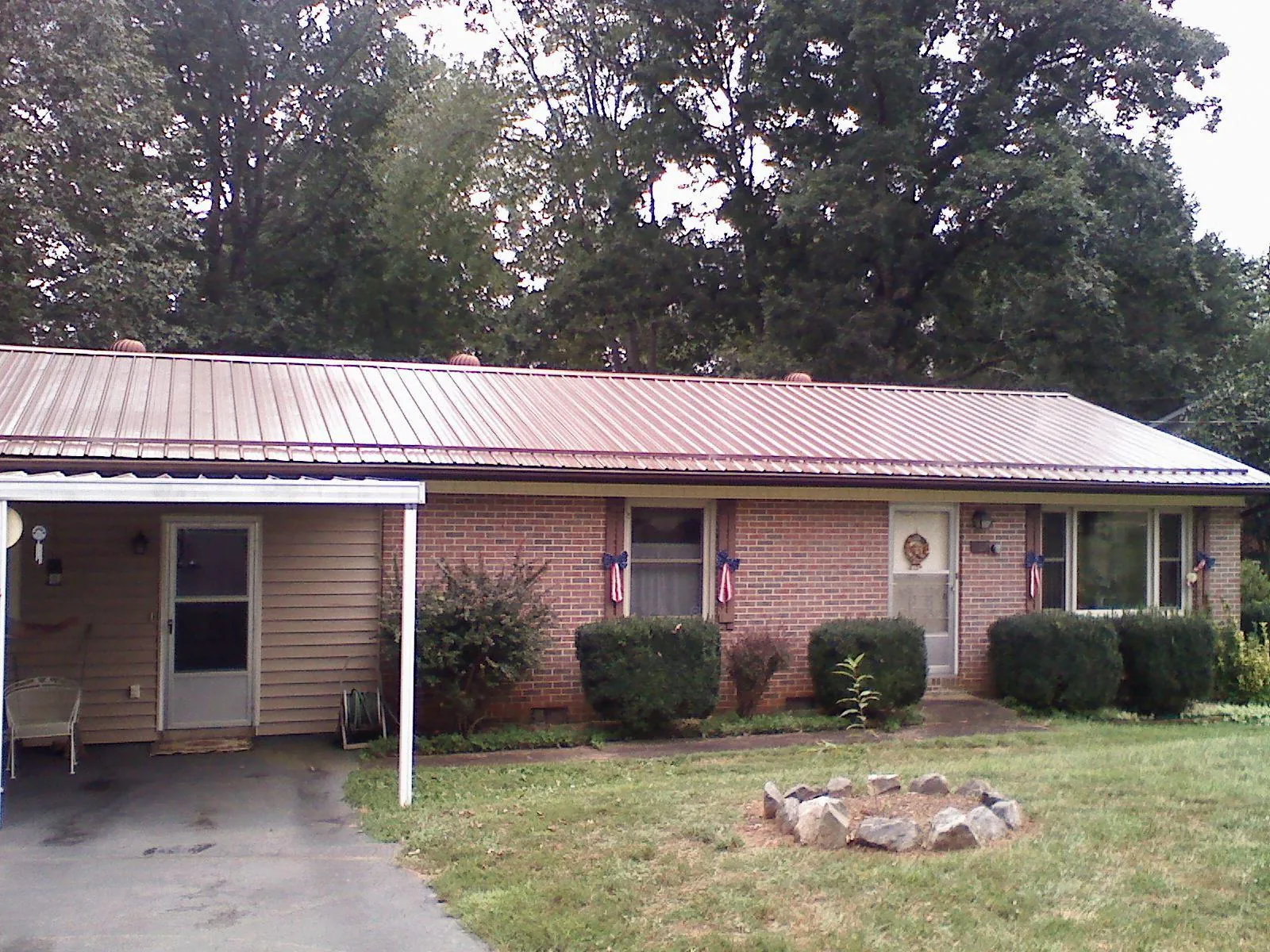 Bronze metal roof and carport on a brick ranch home — Roof Repair work by our crew in Mooresburg